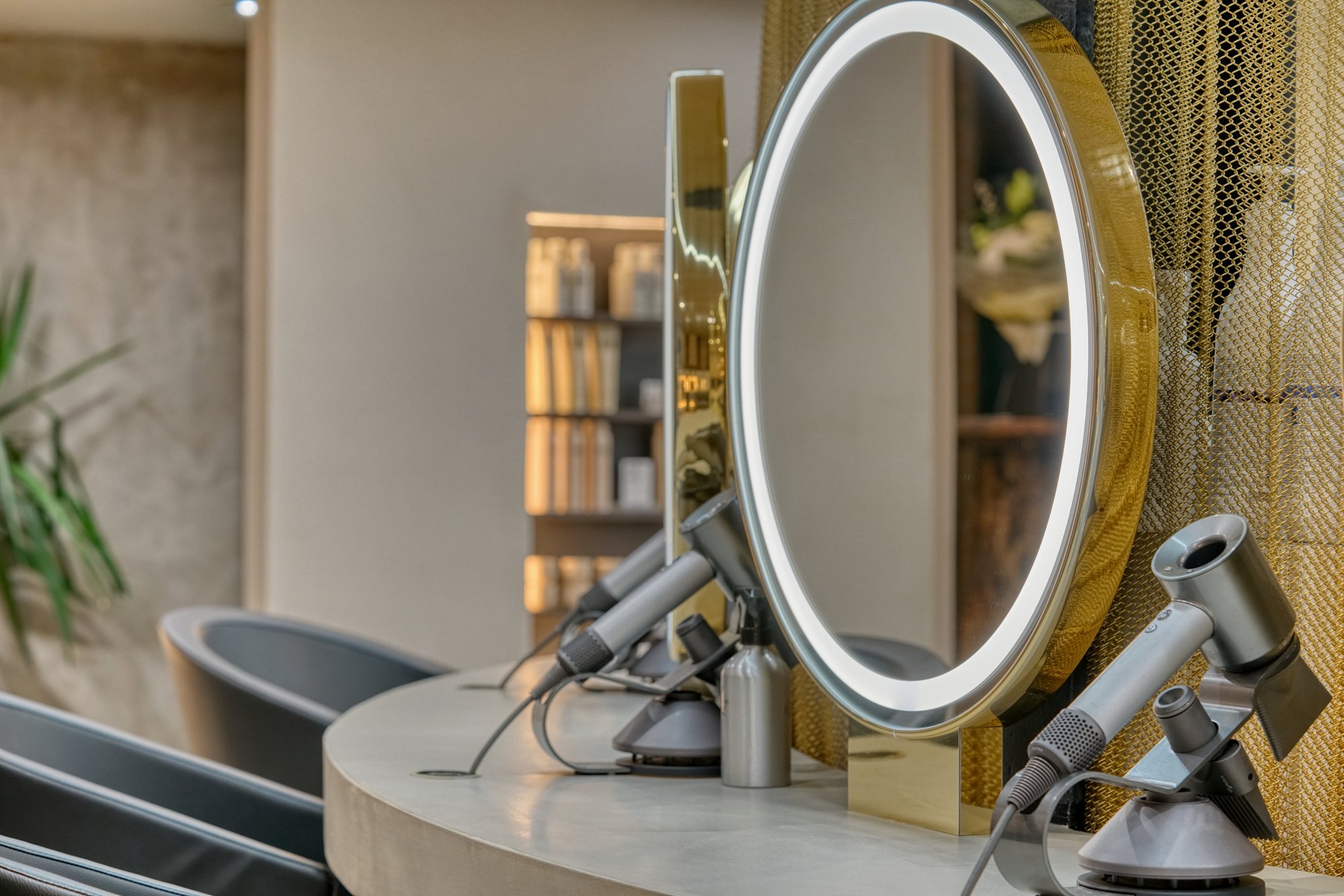 Ring-lit circular mirror and dryers at an Avesta Hair styling station
